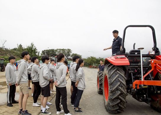 대동공업 농기계 교육관이 학생들에게 트랙터 조작에 대해 설명하고 있다.