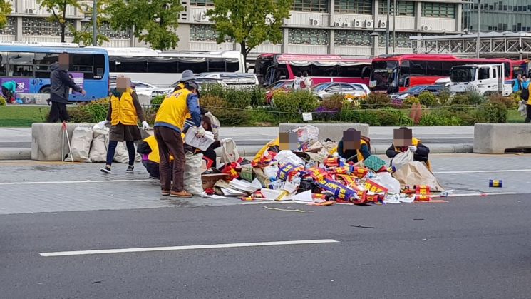 18일 광화문광장에서 열린 '택시 생존권 사수 결의대회'가 끝난 뒤 주최 측 인원들이 쓰레기를 정리하고 있다./이관주 기자
