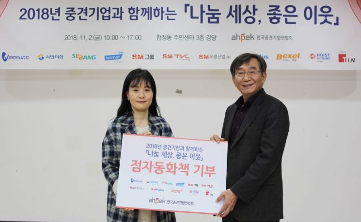 김효연 수원시 장애인복지관 장애인인식개선 강사(왼쪽)와 김규태 한국중견기업연합회 전무(오른쪽)가 점자책 기부 기념식 이후 사진촬영을 하고 있다.