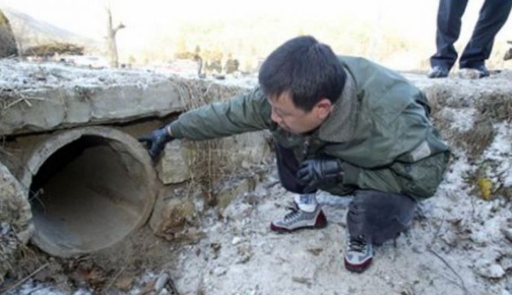 포천 경찰서 관계자가 A 양의 시신이 발견된 배수로를 감식하고 있다.현재 배수로는 터널 공사로 철거됐다.사진=연합뉴스