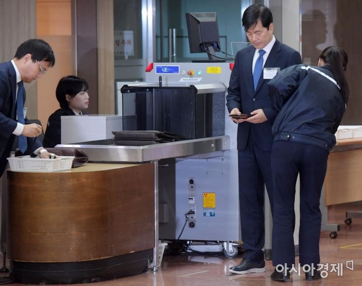 [포토]보안검색 받으며 휴대전화 보는 김태한 삼바 대표