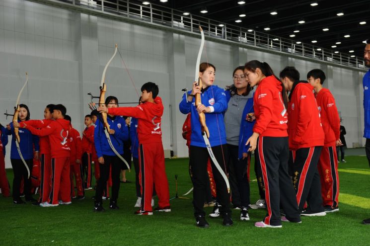현대모비스가 현직 양궁 선수들과 함께 지난 12일부터 16일까지 중국 톈진 지역 어린이를 대상으로 양궁교실을 진행한다. 사진은 현대모비스 여자 양궁단 선수들이 중국 톈진 지역 초·중학교 어린이에게 활 쏘는 법을 알려주는 모습.(사진=현대모비스 제공)