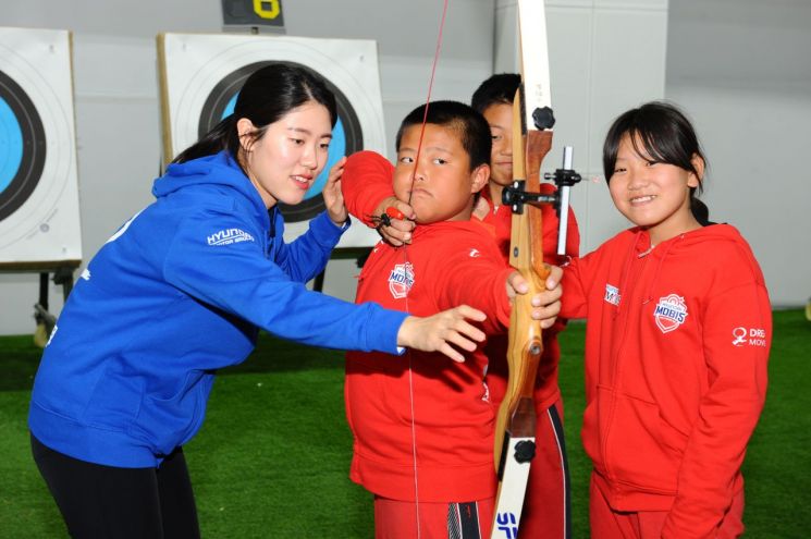 현대모비스 여자 양궁단 선수들이 지난 12일부터 진행된 어린이 양궁교실에서 중국 톈진 지역 초·중학교 어린이에게 활 쏘는 법을 알려주고 있다.(사진=현대모비스 제공)