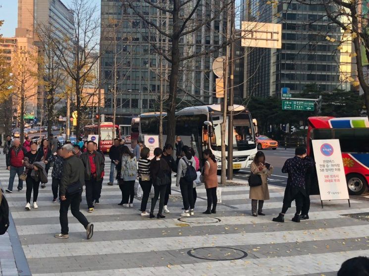5일 신세계면세점 명동점 1층 정문 앞에서 중국인 단체관광객들이 버스에서 내리고 있다.