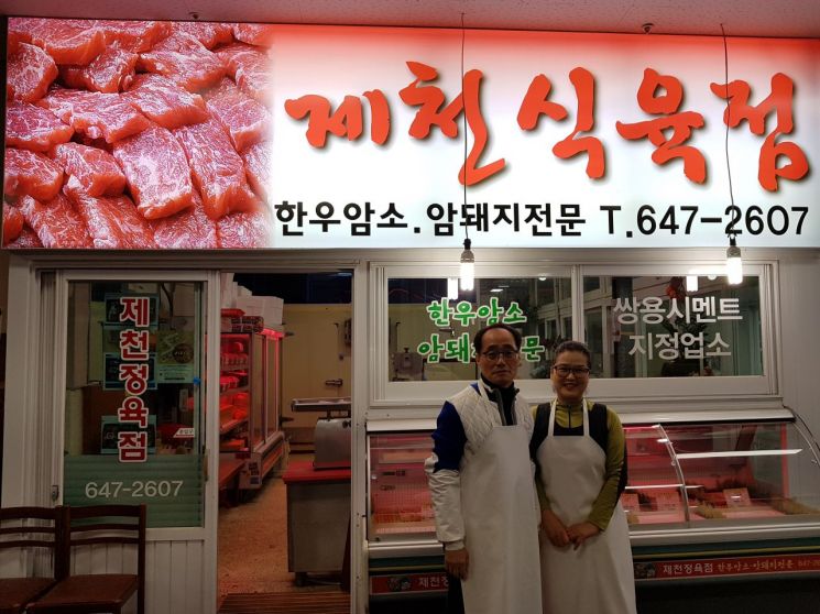 박용준 제천식육점 사장과 부인 김춘자 씨가 가게 앞에서 활짝 웃고 있다.