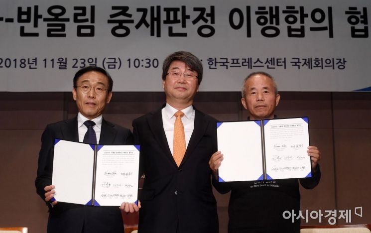 23일 서울 중구 프레스센터에서 열린 삼성전자-반올림 중재판정 이행합의 협약식에서 김기남 삼성전자 사장(왼쪽부터), 김지형 조정위원장, 황상기 반올림 대표가 협약서에 서명한 뒤 기념촬영을 하고 있다./김현민 기자 kimhyun81@