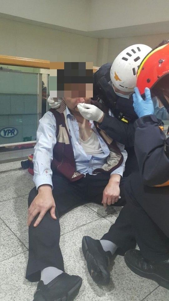 충남 아산시 둔포면 유성기업 아산공장에서 김모상무(사진 왼쪽)가 119 구급대원들로부터 응급치료를 받고 있다. 김 상무는 이날 노조원들로부터 집단 구타를 당해 코와 눈 주위 뼈가 골절됐다. [이미지출처=연합뉴스]