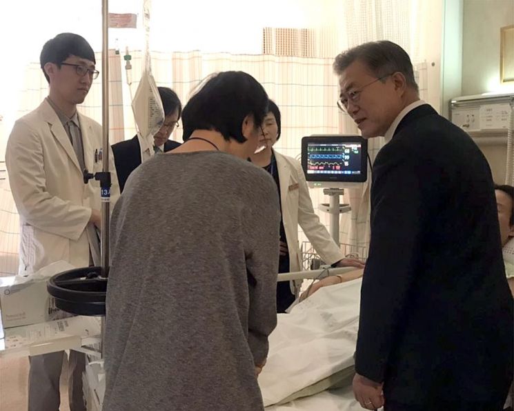 7일 삼성서울병원에서 문재인 대통령이 김모 기획재정부 서기관의 병실을 찾아 부인에게 위로를 전하고 있다. (사진=청와대)