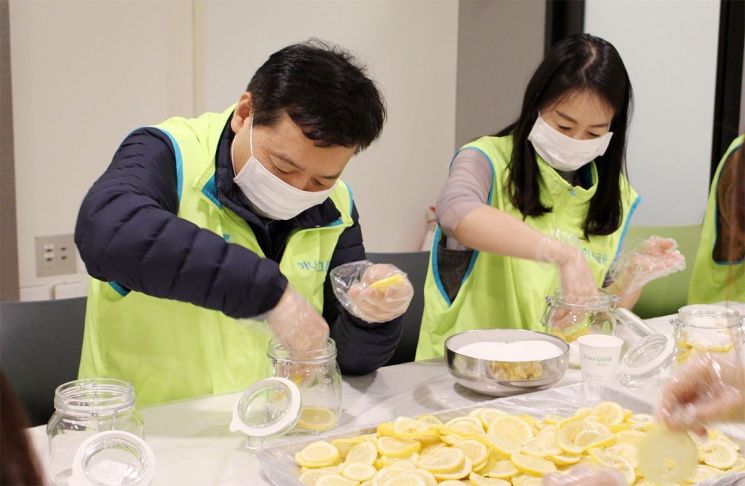 봉사활동에 참여한 윤규선 하나캐피탈 대표이사(사진 왼쪽)이 '사랑봉사단' 직원들과 함께 '레몬청'을 만들고 있다.
