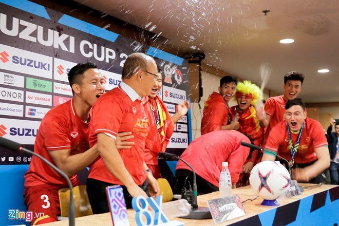 박항서 감독이 스즈키컵에서 우승한 뒤 기자회견 하는 도중 베트남 선수들이 찾아와 음료를 뿌리며 장난치고 있다.[사진=베트남 매체 '징' 홈페이지]