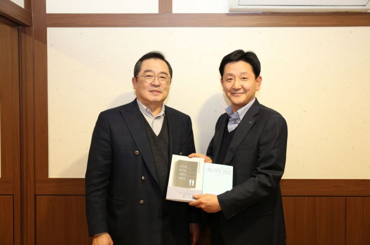 구자열 LS그룹 회장이 14일 LS용산타워에서 신규 임원이된 LS산전 박석원 이사에게 책을 선물하고 있다.