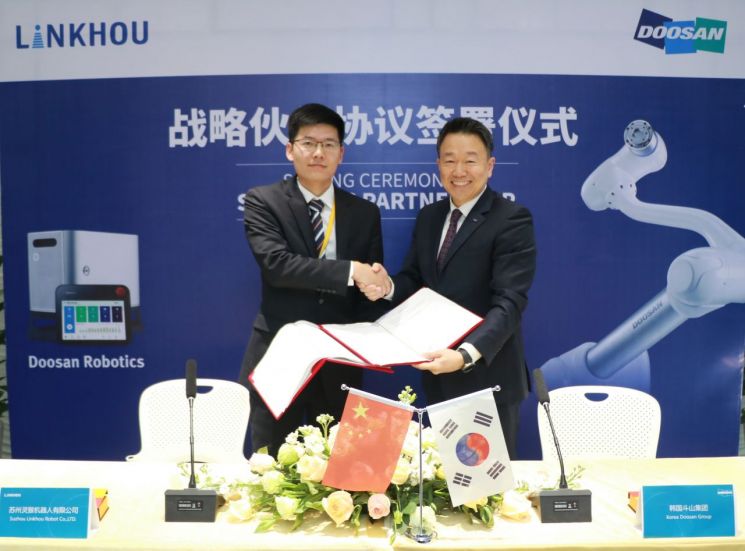 두산로보틱스는 중국 쑤저우에서 중국 최대 산업자동화 솔루션 전문기업인 보존 그룹의 링호우와 두산로보틱스 협동로봇 공급을 위한 대리점 계약을 체결했다. 이병서 두산로보틱스 대표(오른쪽)와 동하우 링호우 대표가 계약서에 서명한 뒤 기념촬영을 하고 있다.