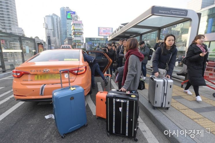 카카오 카풀 서비스 도입에 반대하는 택시업계가 총파업에 돌입한 20일 서울역 택시승강장에서 외국인 관광객들과 출근길 시민들이 택시를 기다리고 있다. /문호남 기자 munonam@
