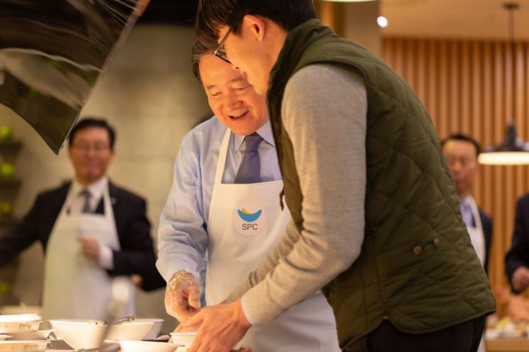 2일 양재동 SPC그룹 본사에서 허영인 SPC그룹 회장(왼쪽)이 임직원들에게 떡국을 배식하고 있다.