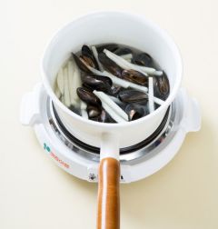 4. 5분 정도 지나 무가 어느 정도 익으면 홍합을 넣어 끓인다.  거품을 걷어내며 5분 정도 더 끓여 대파를 넣고 소금으로 간을 한다.