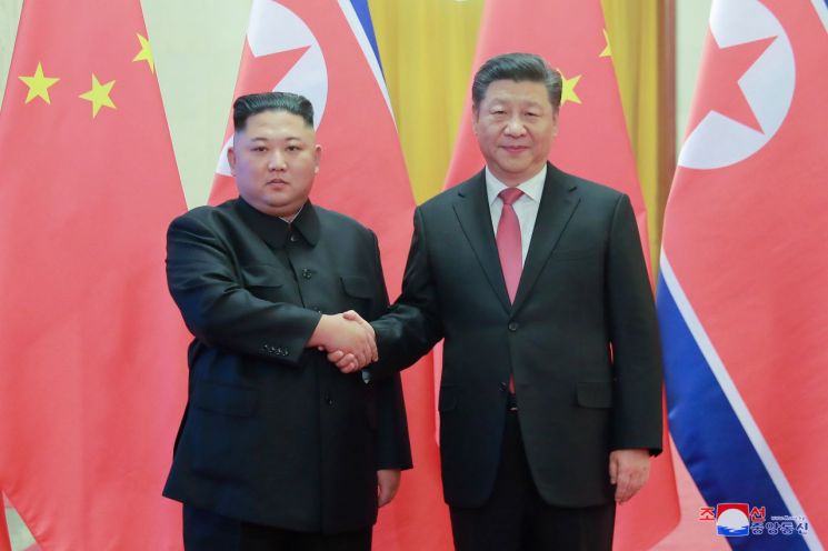 네 번째로 중국을 방문한 김정은 북한 국무위원장(왼쪽)이 지난 1월 8일 인민대회당에서 시진핑 중국 국가 주석과 악수하는 모습을 조선중앙통신이 10일 보도했다.