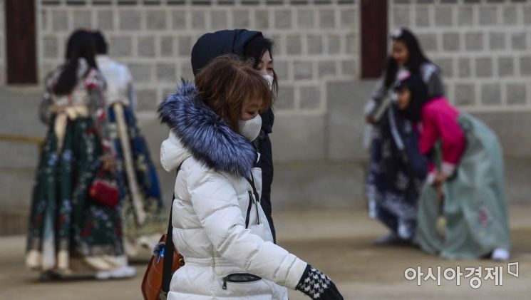 수도권 대부분 지역에 미세먼지 비상 저감조치가 내려진 14일 서울 종로구 경복궁에서 관광객들이 마스크를 착용한채 발걸음을 옮기고 있다./강진형 기자aymsdream@
