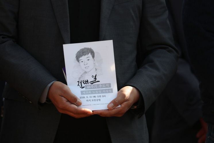 3일 경기도 남양주시 모란공원에서 열린 고(故) 전태일 열사 48주기 추모제에서 추모객이 열사의 얼굴이 담긴 안내책자를 들고 있다. 2018.11.13 [이미지출처=연합뉴스]
