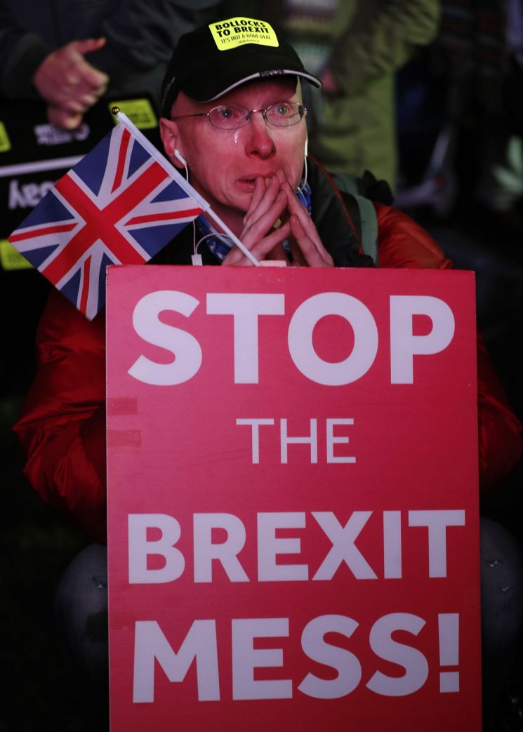 "제발, 스톱"　15일(현지시간) 영국 런던 의사당 앞 광장에서 영국 국기인 유니언잭과 플래카드를 들고 브렉시트(Brexitㆍ영국의 유럽연합(EU) 탈퇴) 반대 시위를 벌이던 한 남성이 하원의 합의안 부결 소식을 전해 듣고 눈물을 흘리고 있다. [이미지출처=AP연합뉴스]