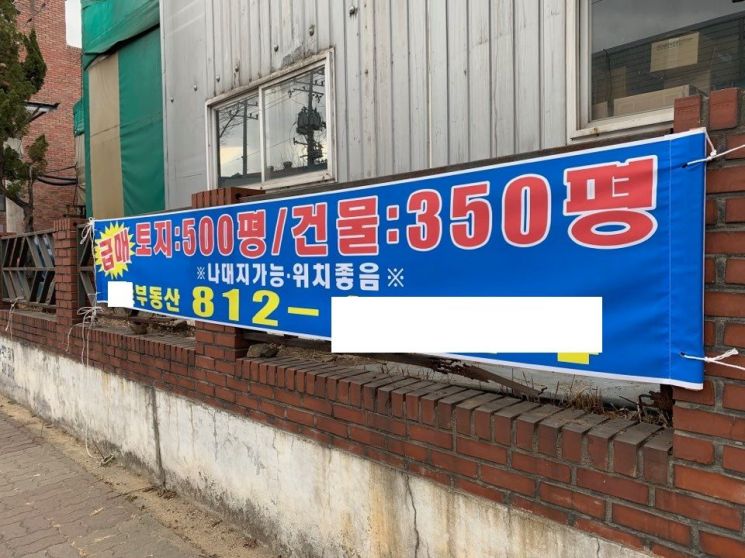 남동산단의 한 건물 외벽에 토지와 건물 매매를 알리는 현수막이 붙어있다. '급매'를 강조하는 표시가 눈에 띈다.