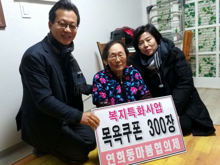 최재숙 연희동 마봄협의체 위원장(오른쪽)과 석도현 연희동장(왼쪽)이 지역 내 어르신 가정을 방문해 목욕 쿠폰을 전해드렸다.