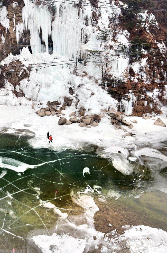 겨울 혹한기에만 가능한 한탄강 얼음 트래킹은 물속까지 훤히 들여다보이는 얼음장 위를 걷노라며 오금이 저려오지만 짜릿한 묘기가 있다. 여행객이 승일교아래 한탄강을 걷고 있다.