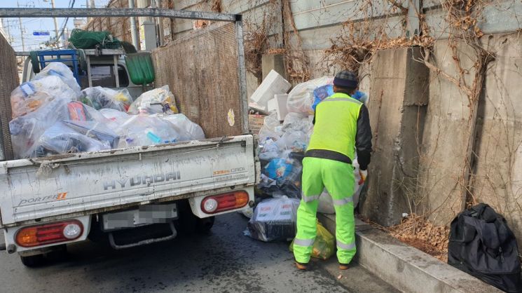 설 연휴가 끝난 7일 오전 서울 동대문구의 한 주택가에서 환경미화원 이모(63)씨가 연휴 기간 쌓인 재활용 쓰레기를 수거하고 있다.
