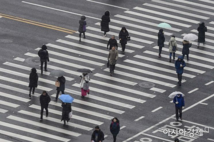 전국 곳곳에 눈이 내리고 있는 15일 서울 중구 서울시청 인근에서 시민들이 우산을 쓴채 발걸음을 옮기고 있다./강진형 기자aymsdream@