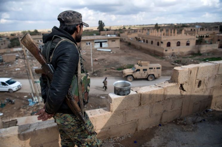 17일(현지시간) 이슬람국가(IS)의 마지막 점령지인 시리아 동부 바구즈에서 국제동맹군의 IS 격퇴전 지상군 부대인 쿠르드·아랍연합 '시리아민주군'(SDF) 대원이 건물 꼭대기에 올라 경계를 서고 있다. (사진=AFP연합뉴스)