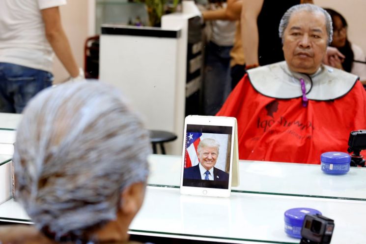 레 푹 하이씨가 도널드 트럼프 대통령의 사진을 바라보며 염색을 하고 있다. [이미지출처=로이터연합뉴스]