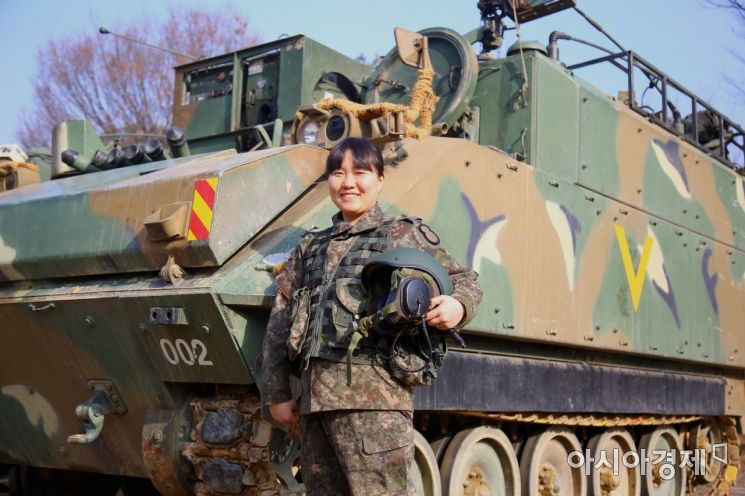 여군 최초의 전투부대 장갑차 조종수 신지현 하사가 장갑차 앞에서 기념촬영을 하고 있다. (사진=육군)