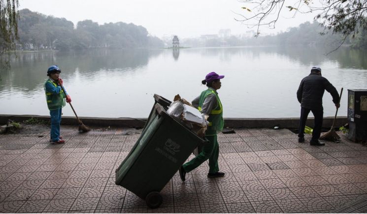 베트남 당국이 고용한 청소 인력들이 하노이 호안끼엠 호수 주변을 청소하고 있다. (사진출처:SCMP)