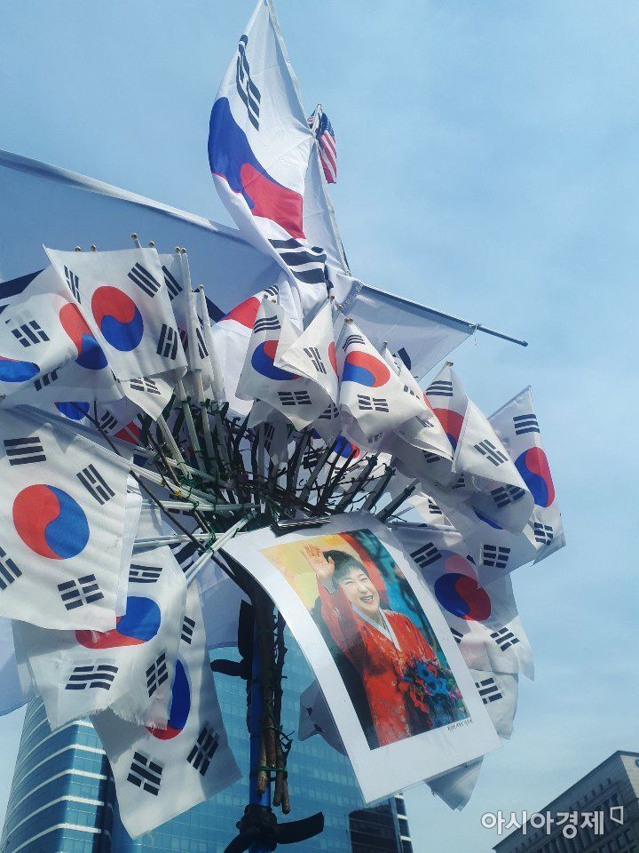 A(67) 씨가 직접 제작한 박 전 대통령 석방 기원 홍보물. 그는 수 많은 태극기 사이에 박 전 대통령 사진을 넣어 시민들에게 보이고 있었다.사진=한승곤 기자 hsg@asiae.co.kr