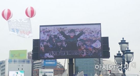 9일 오후 1시 서울역 광장에 설치된 한 스크린에 박근혜 전 대통령의 대통령 당선 직후 환호하는 모습이 나오고 있다. 사진=한승곤 기자 hsg@asiae.co.kr
