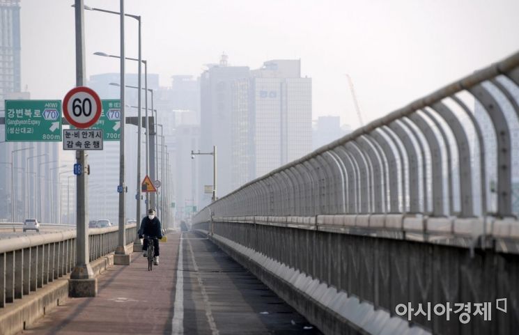 중서부 지역 미세먼지 농도가 '나쁨' 수준을 보인 15일 서울 마포대교에서 마스크를 쓴 시민이 자전거를 타고 있다. /문호남 기자 munonam@