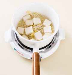 3. 냄비에 물 2컵과 콩나물을 넣어 뚜껑을 덮고 끓여 김이 오르면 2~3분 정도 더 끓인다. 뚜껑을 열어 두부를 넣는다.