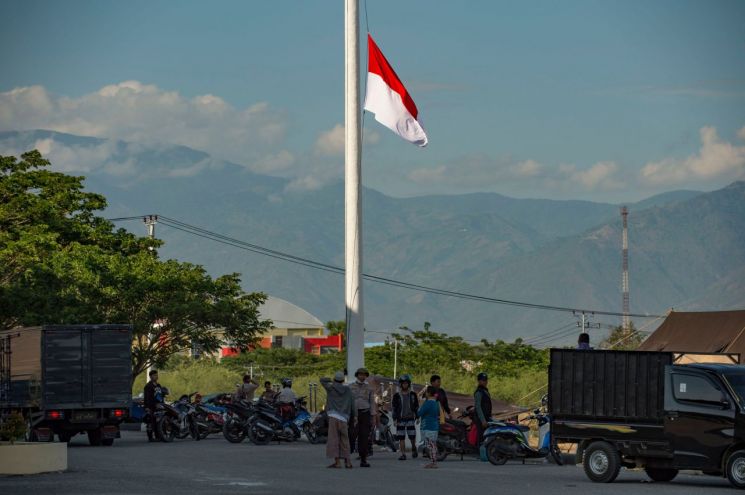 지난해 9월 강진이 발생한 뒤 술라웨이섬 팔루의 임시 대피소 앞에 인도네시아 국기가 조기로 게양된 모습. (사진=연합뉴스)