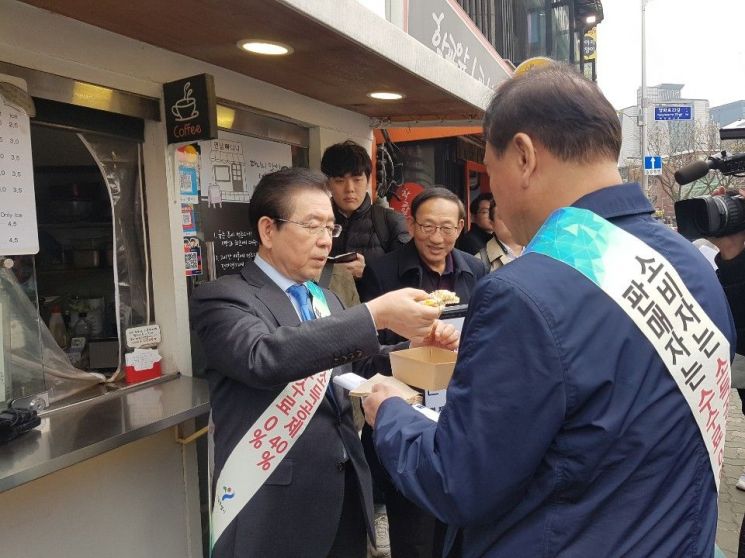 박원순 서울시장이 25일 제로페이 시연회에 참석해 제로페이로 결제한 뒤 구매한 음식을 나눠 먹고 있다.