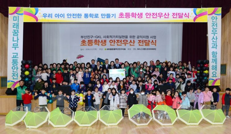 GKL이 지난해 12월 부산진구와 초등학생 안전우산 전달식 행사를 하고 기념촬영을 하고 있다.[사진=GKL 제공]
