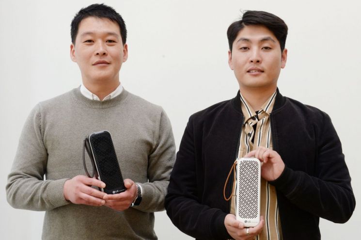 전종건 LG전자 홈어플라이언스&에어솔루션(H&A) 상품기획담당 책임(왼쪽)과 구명진 LG전자 에어솔루션연구소 선임연구원이 휴대용 공기청정기 '퓨리케어 미니'를 들고 포즈를 취하고 있다.