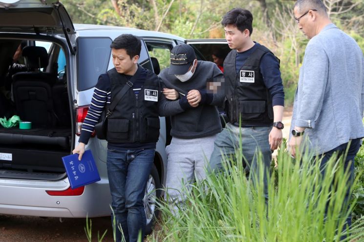 의붓딸을 살해하고 시신을 저수지에 유기한 혐의(살인 및 사체유기)로 구속된 김모(31)씨가 현장검증을 위해 1일 전남 무안군 한 농로를 이동하고 있다. (사진=연합뉴스)