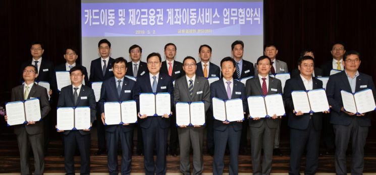 최종구 금융위원장(앞줄 왼쪽에서 네 번째), 김학수 금융결제원장(앞줄 왼쪽에서 다섯 번째)을 비롯한 참석자들이 '카드이동 및 제2금융권 계좌이동서비스 업무협약'을 하고 기념사진을 찍고 있다. (앞줄 왼쪽부터) 조태원 산림조합중앙회 상호금융상무, 황국현 새마을금고중앙회 지도이사, 박재식 저축은행중앙회장, 최종구 금융위원장, 김학수 금융결제원장, 김덕수 여신금융협회장, 홍재문 은행연합회 전무, 안호근 농협중앙회 상호금융상무, 박신철 수협중앙회 조합감사위원장 (사진 금융위원회 제공)