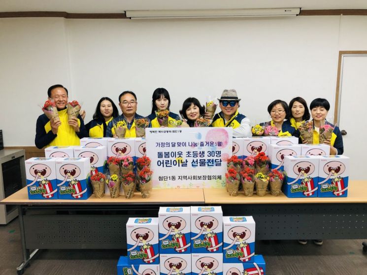 광주광역시 광산구 첨단1동 지역사회보장협의체가 초등학생 30명에게 어린이날 선물을 전달하고 기념사진을 찍고 있다.