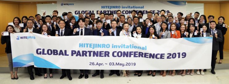 '2019 글로벌 파트너 콘퍼런스'에 참가한 아시아태평양 지역 6개국 글로벌 파트너들과 하이트진로 해외사업본부 직원 등 총 60여명이 사원증을 들고 기념 촬영을 하고 있다.