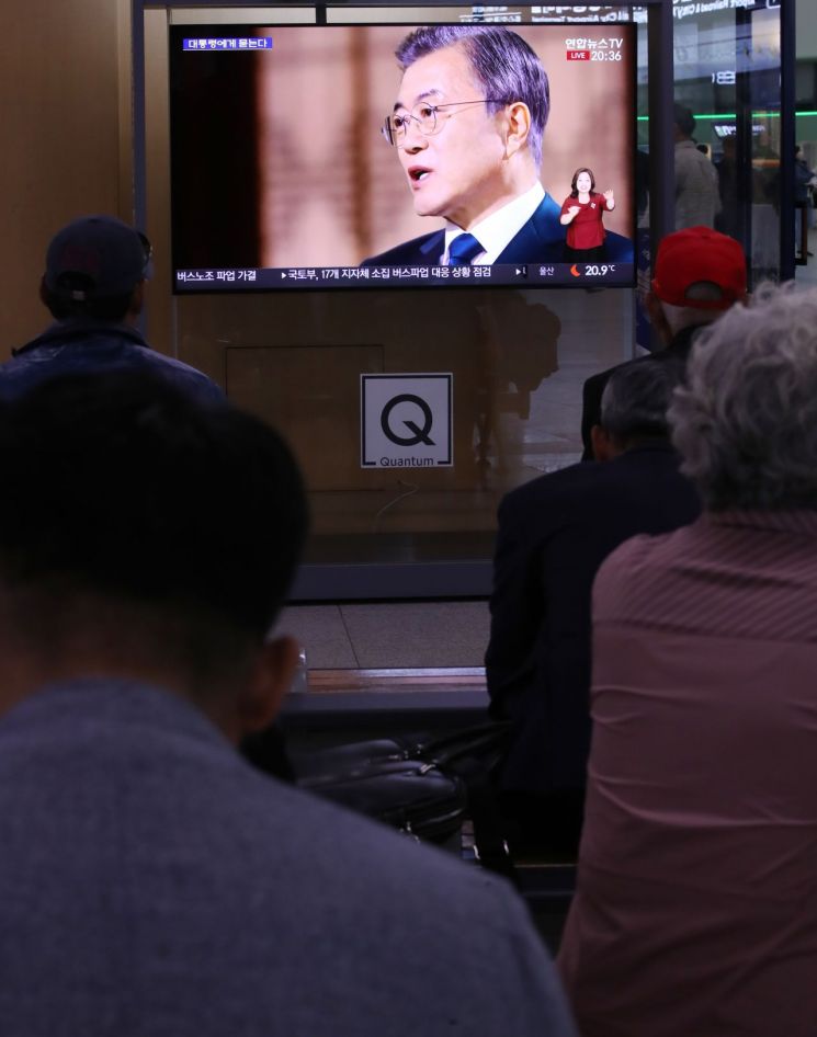 9일 오후 서울역에서 시민들이 문재인 대통령 취임 2주년 특집 대담' 대통령에게 묻는다'를 TV로 시청하고 있다.