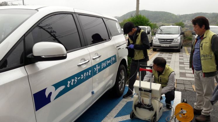 한국석유관리원 검사원들이 전국 지역별 '교통약자 이동지원센터'에서 운영하고 있는 특별교통수단차량에 대한 연료 품질검사를 위해 차량에 주유된 연료를 뽑아내고 있다.
