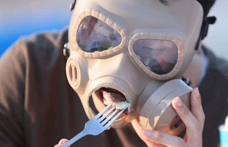 14일 광화문광장에서 열린 '미세먼지 속의 다이닝'행사에서 참석자가 마스크를 쓰고 식사를 하는 모습. 사진 = 연합뉴스