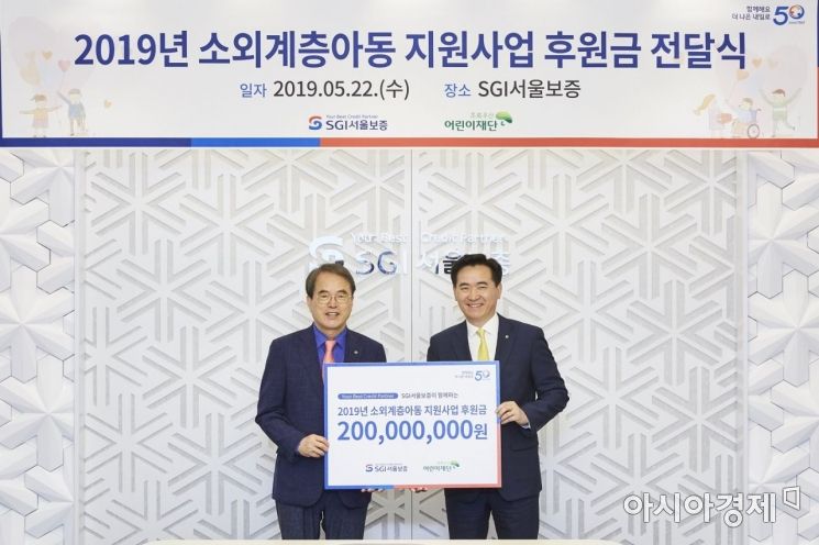김상택 SGI서울보증보험 사장(오른쪽)은 22일 서울 종로 서울보증 본사에서 이제훈 초록우산 어린이재단 회장에게 기부금을 전달하고 있다.