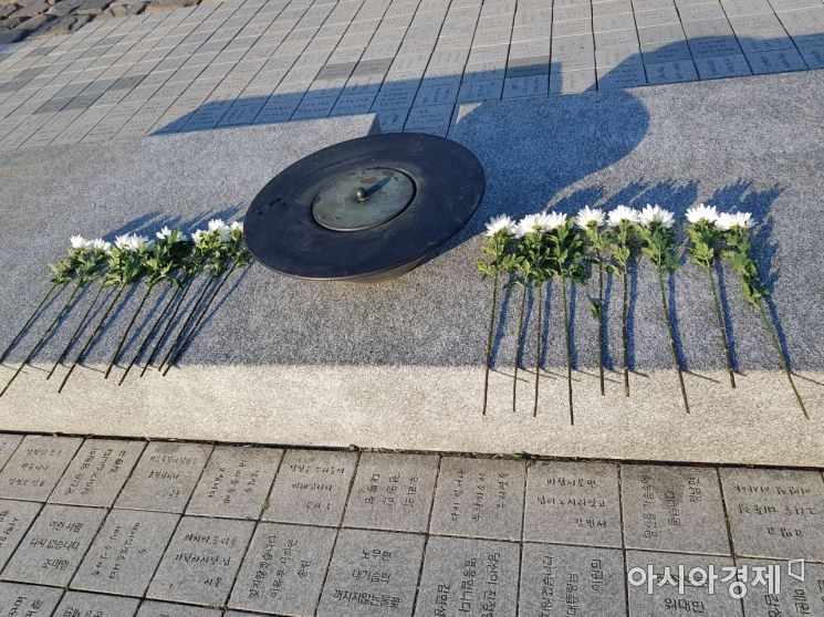 22일 경남 김해 봉하마을 대통령 묘역에 참배객들이 놓고 간 흰 국화가 쌓여있다. (사진=원다라 기자)
