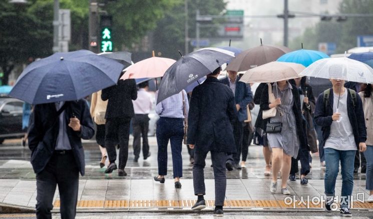 이른 더위를 식히는 비가 내리고 있는 27일 서울 종로구 세종로 네거리 인근에서 직장인들이 우산을 쓰고 출근길에 오르고 있다./강진형 기자aymsdream@